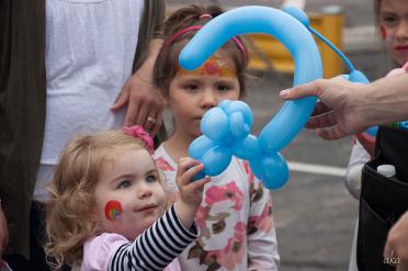Balloon artist hands child a balloon monkey at kids party in Fesus Missouri