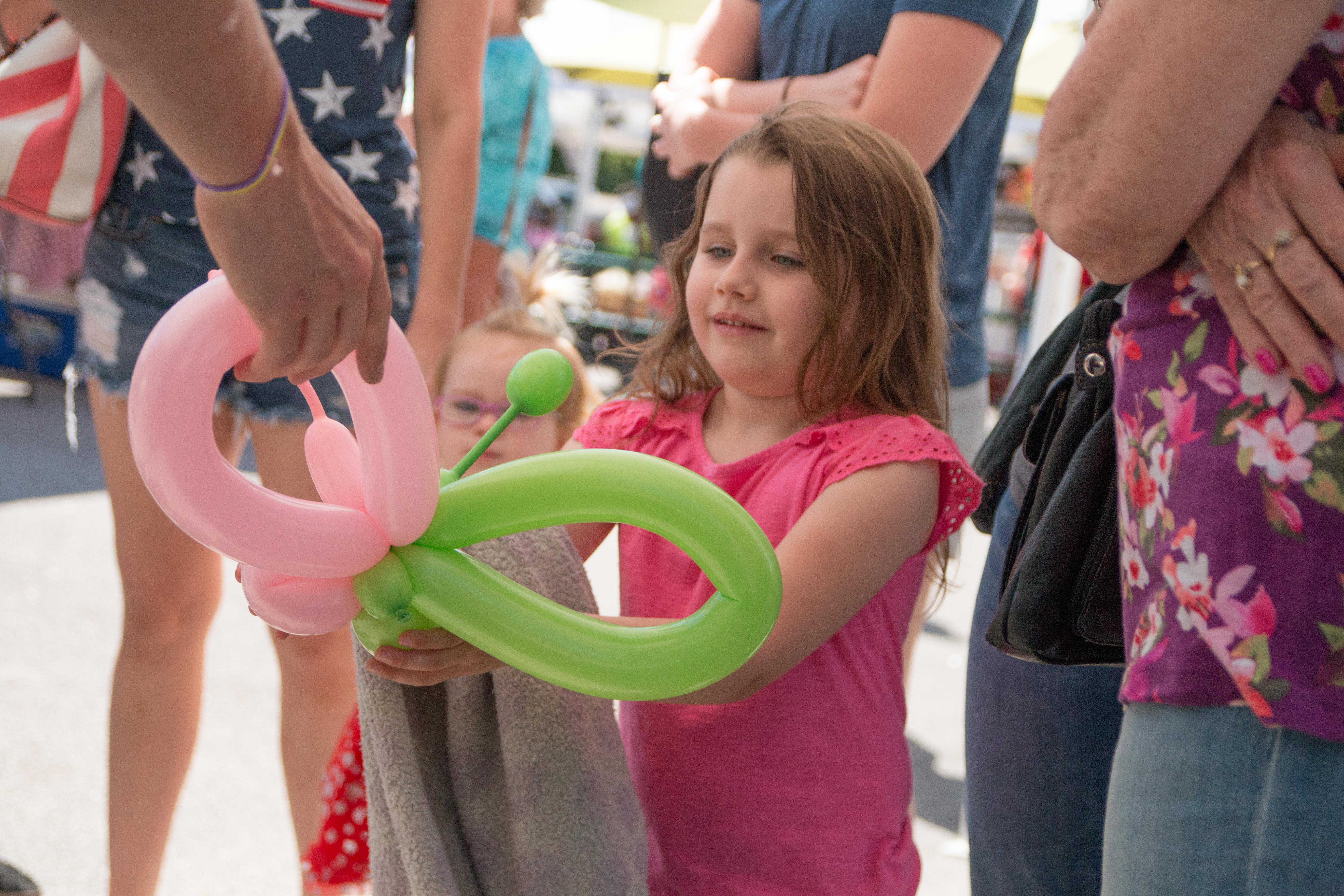 Balloon twister hands child a balloon butterfly in Ferguson Missouri