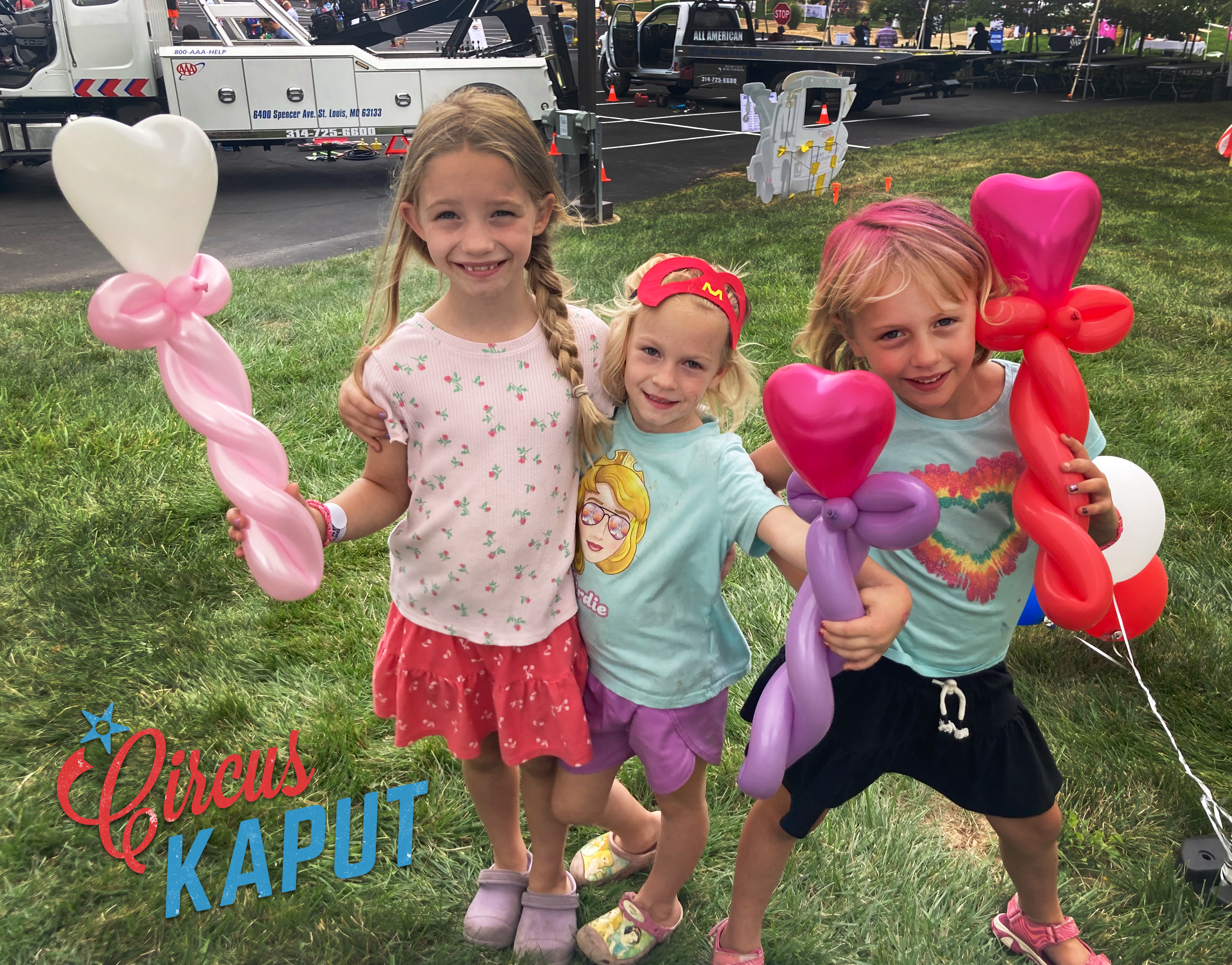 Three kids hold heart balloons at community event in Olivette Missouri