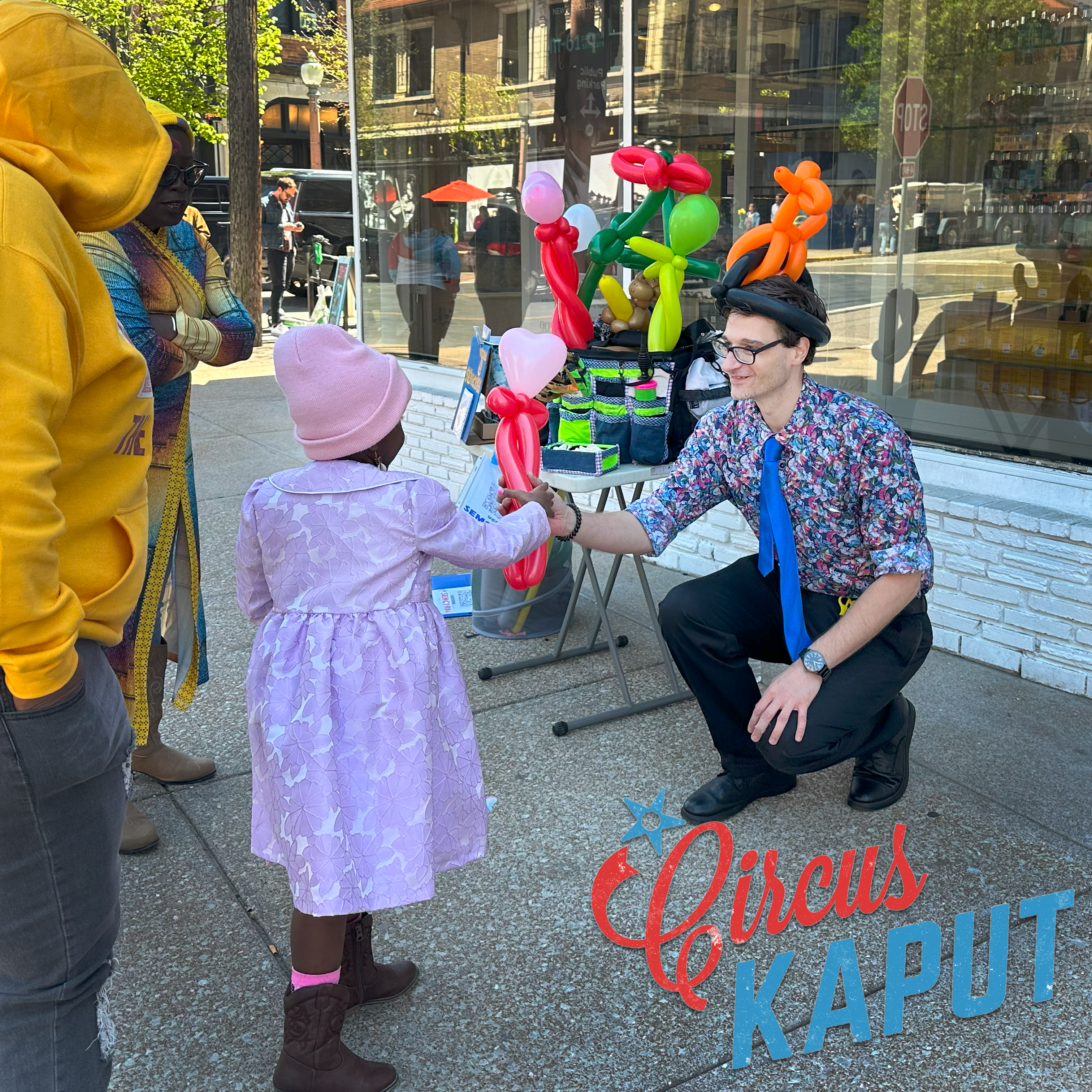 Balloon Twister hands a child a heart balloon in Central West End St. Louis